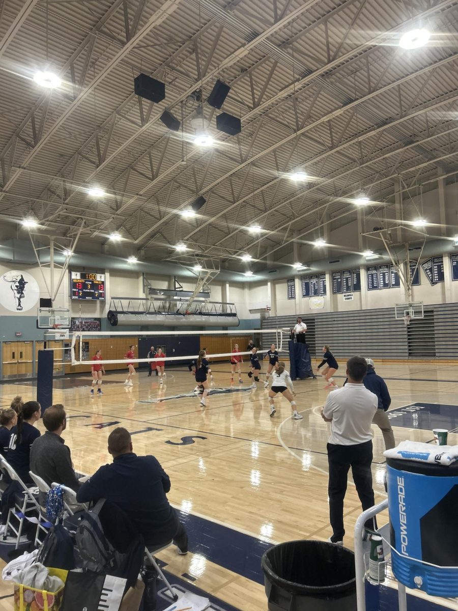 Olivia Lyons (Left), and Lana Gillas (Right) are blocking the ball from getting over the net. It is the middle of the third set and the Wildcats are tied with Centennial 13-13.