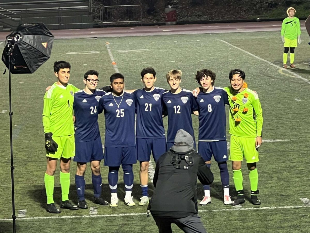 Seniors stand smiling for a picture on their senior night. The team would go on to win 5-3. 