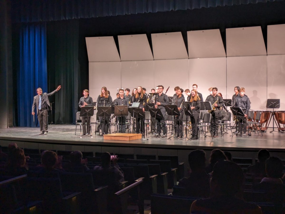 Instrumental music director Chad Davies smiles as he points to his performers during the band concert. The fall concert marked the first band performance in the new auditorium!