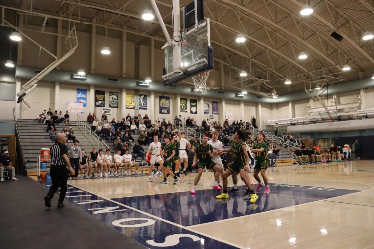 Senior Kyle Counts shoots a three as his teammates and fans eagerly wait for the ball to go into the hoop. Counts went on to drop 21 points in the Wildcats 63-59 win over Putnam. 