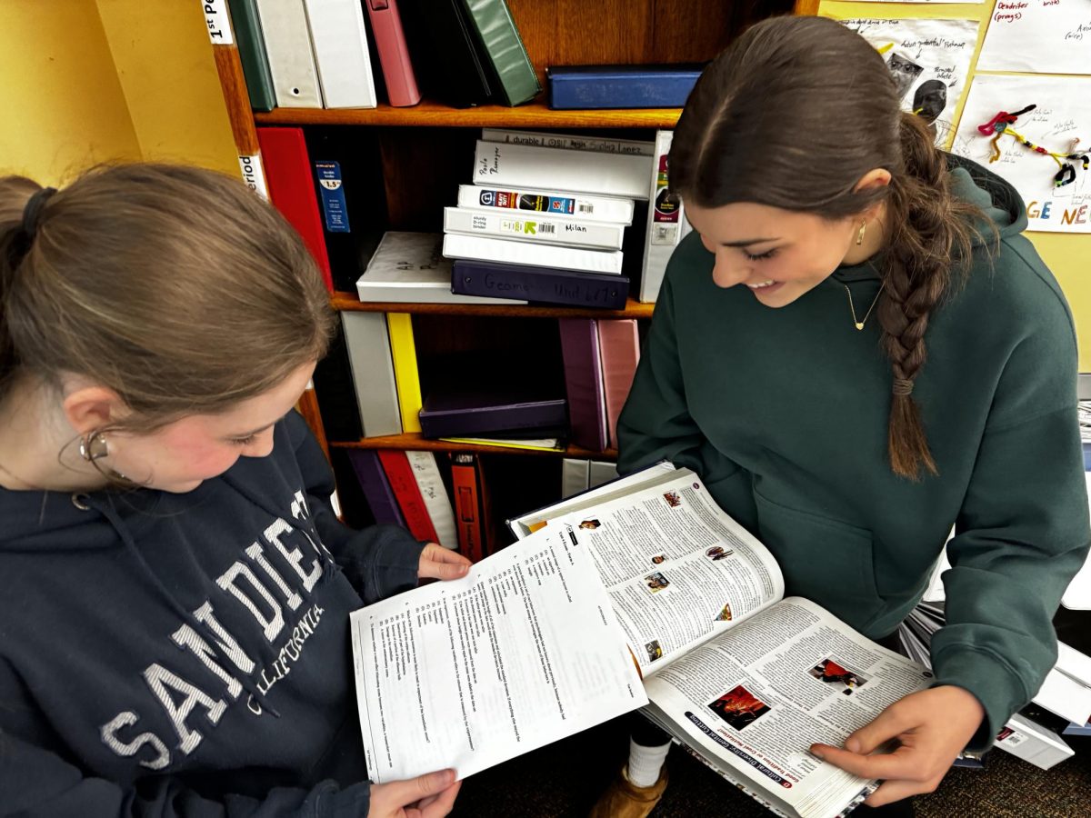 Sophomores Avery Underhill and Sofia Kerner pose with AP Psychology textbook and a test packet. Both Underhill and Kerner are enrolled in this elective and study thoughtfully to excel in class. 