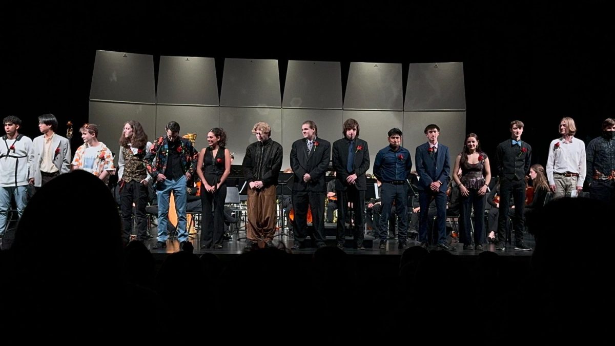 Band and orchestra seniors standing on stage, recieving recognition at their final concert for all their hard work over the past 4 years. The experiences of Class of 2024 will live with them forever, but most importantly, the legacy they leave behind will have a positive ripple effect for future generations of Wilsonville musicians. Photo provided by Kevin Bruce.