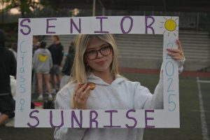 Lizzy Owens poses with her Senior Sunrise sign. The early morning brought much fun to the class of 2025. 