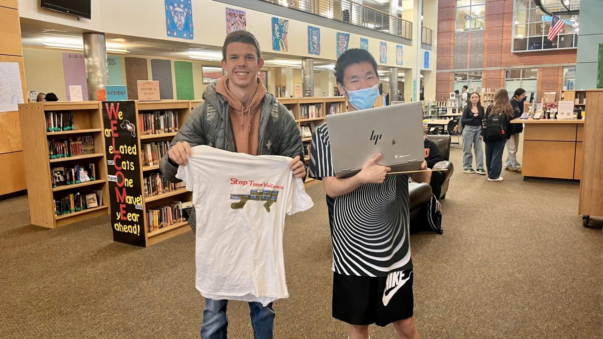 Xin-Xin poses with junior, Ryan Williams, and his personalized swag. Merchandise  is thoughtfully customized and delivered to students through Xin-Xin's business. 