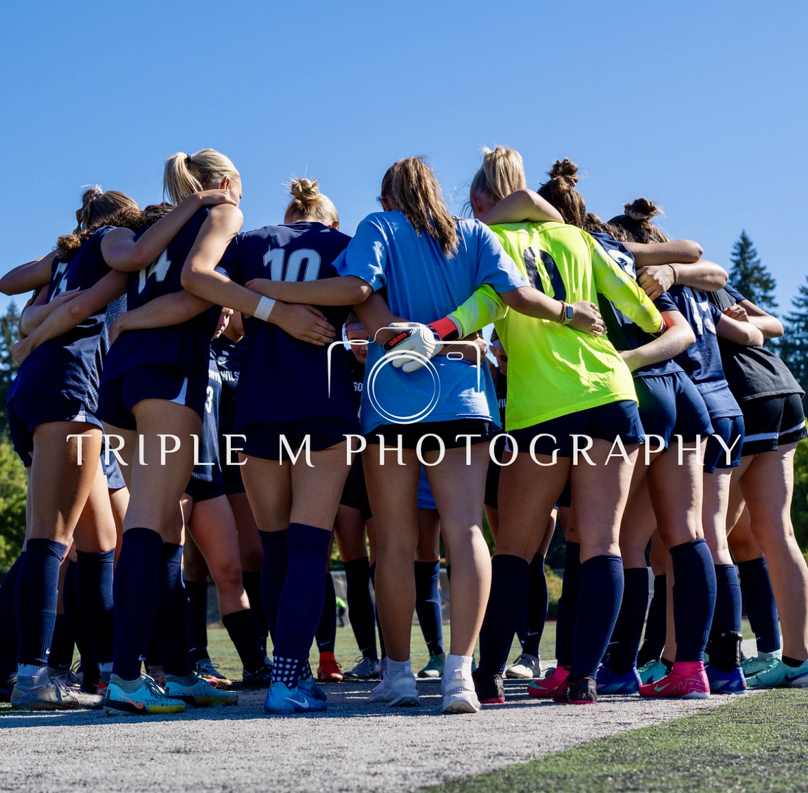 Wilsonville Girls' Varsity soccer huddles before the kick off game to the season. Pulsing with anticipation and excitement, the team hypes one another before storming onto the field.  