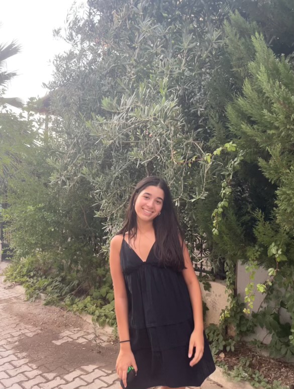 Yaamani Aga poses outside of her house with a backsplash of lush greenery. A dedicated student and leader of the community, Aga leaps into both academics and extracurriculars ready to face anything.