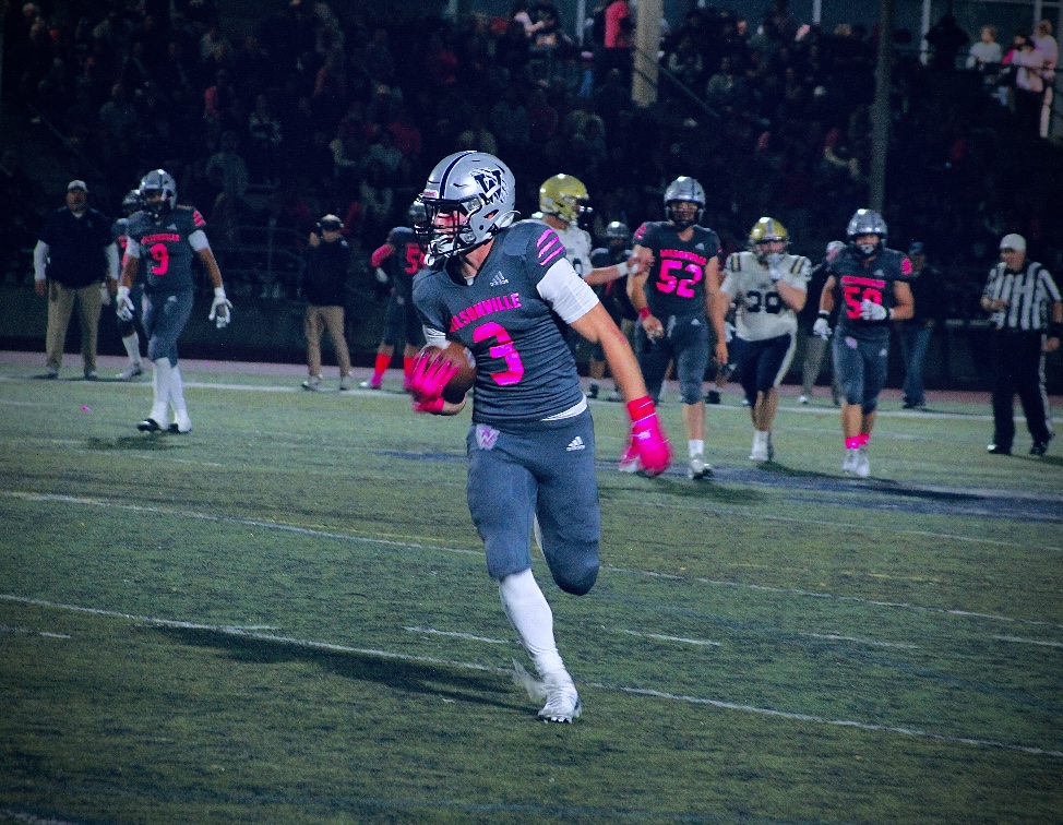 Number 3, a senior at Wilsonville, Nick Crowley, runs the ball a couple of yards in the homecoming game against the Canby Cougars. 