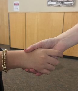 A shaking of hands, representing the meaning of positive resolutions. It can be detrimental to not know the impacts of negative interactions with others, especially when it leads to physical conflict.