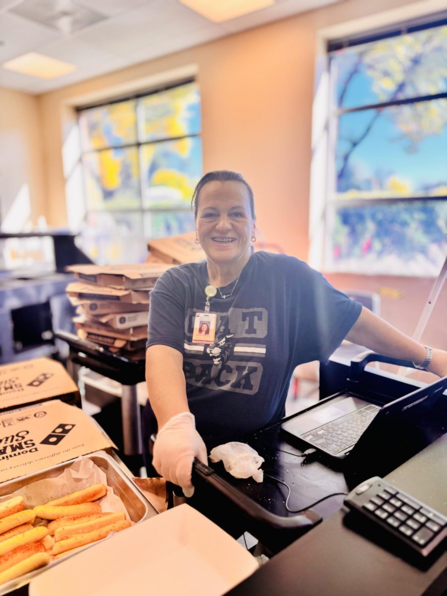 One of Wilsonville's lunch servers, Helen Williams, stands ready to help students purchase lunch. With fresh breadsticks to her left, she serves many hungry students and supports their academic and athletic journeys by supplying them nutrients and snacks to fuel them through the day. 