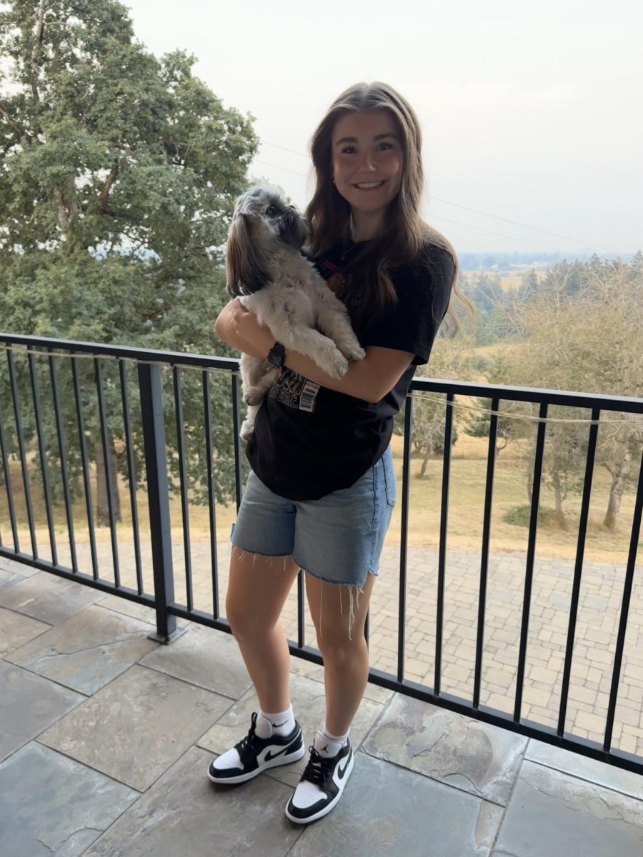 Junior Gabi Moultrie stands outside her home holding her dog, Rolex. Photo provided by Gabi Moultrie.