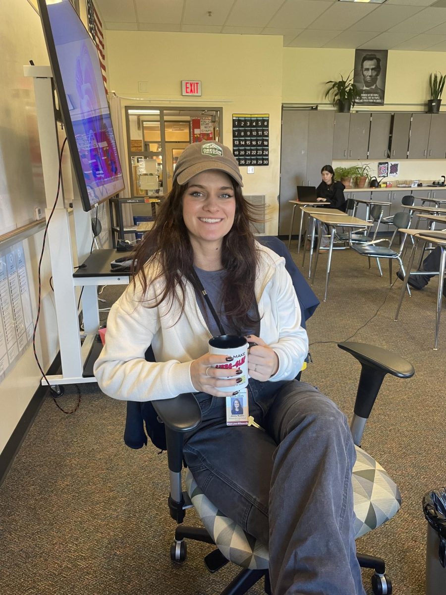 Modern US and AP World History teacher Mrs. Zimmerman poses in her classroom holding her coffee. She mentions a lot of the time coffee motivates her at school, but the students are what makes her day go by faster. Mrs. Zimmerman has impacted many students’ lives, and has enriched Wilsonville High Schools staff. 