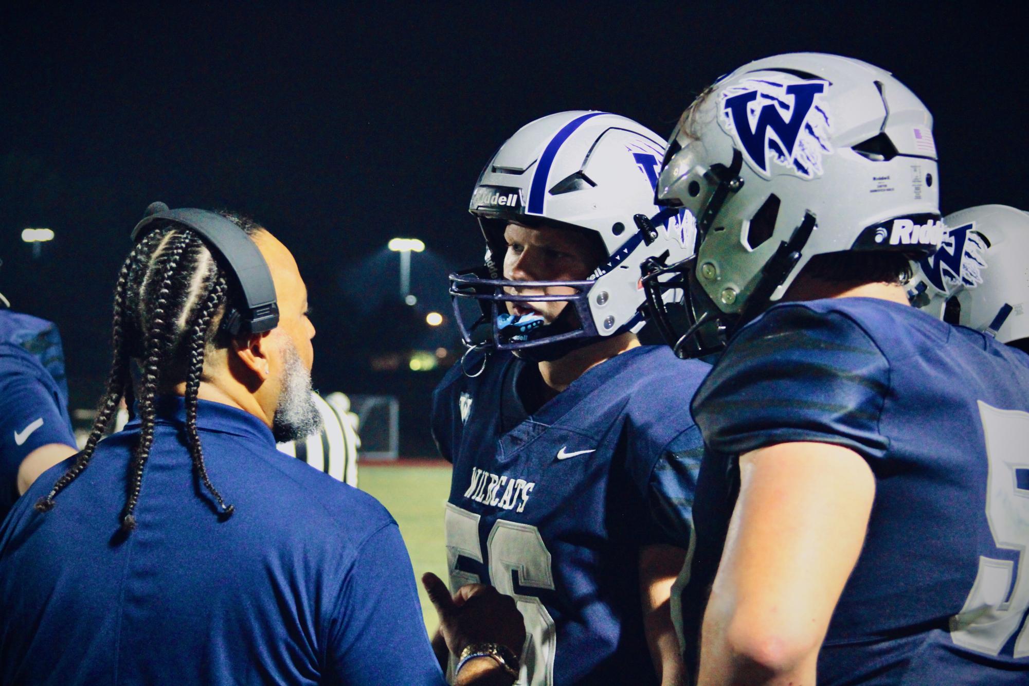 Senior linemen strategize and learn from assistant Varsity coach. Consistently, coaches give side notes to individual players to grow each play and become better every second. 