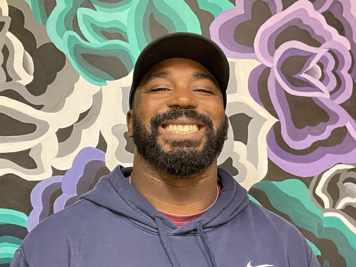 School safety and and enforcement specialist Marcus Washington poses for a photo. Since joining the Wilsonville community in 2022, Washington has found a home in the football team, coaching students to succeed both in class and on the field.