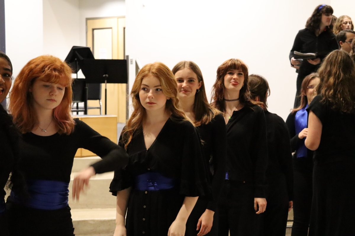 Members of Symphonic Choir wait in the PAC lobby as the performance begins. Inside the theater, Chamber Orchestra and Symphonic Band prepare instruments and settle in on stage. 