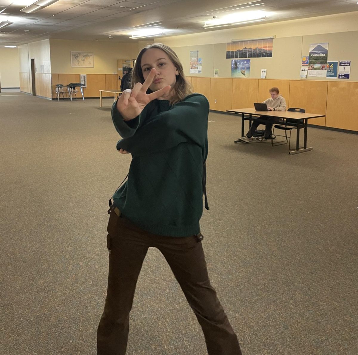 Junior Sydney Cederberg flexes a peace sign to the camera. As a softball and choir member, Cederberg has found passion in her challenges by involving herself in activities beyond the classroom.