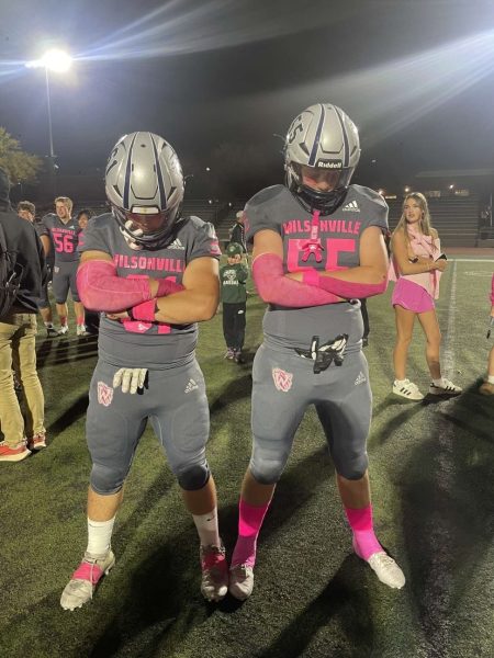 Juniors Tyler Bicknell and Cole McConnaughey pose in after a win during Wilsonville's Homecoming game. Wilsonville and many other teams wear pink during October to show there support for breast cancer awareness.