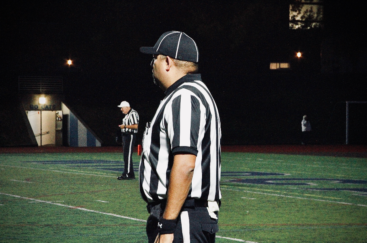 Football referee standing on the football field at Randall Stadium. Fortunately, most football games consist of enough refs for the varsity team.