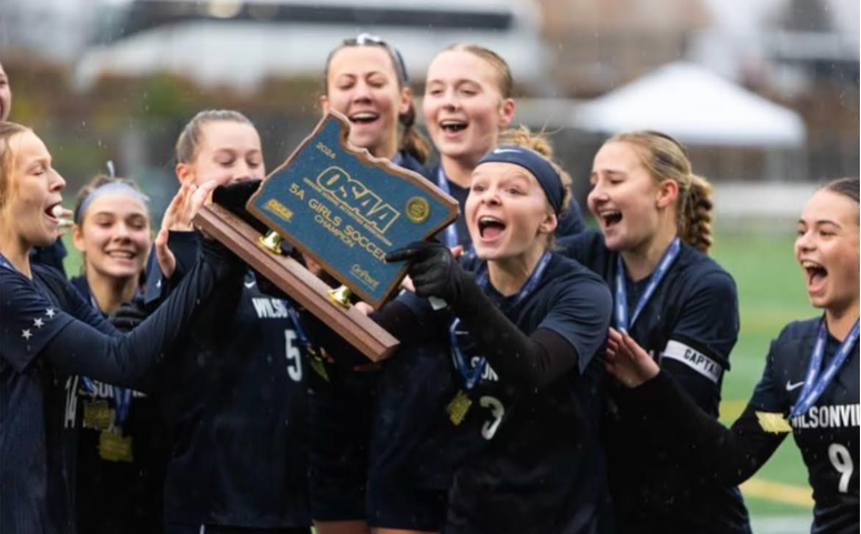 Wilsonville Girls Varsity Soccer team holding teh 5A State champinionship plaque.