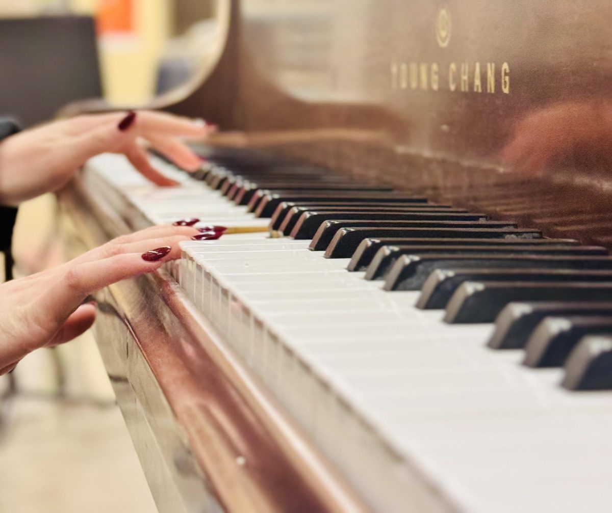 Andrea Ormsby delicately plays the piano set up in the choir room. While many choir students are vastly talented, it's the job of the choral leader to kick off each song with piano tempo and rhythm. 