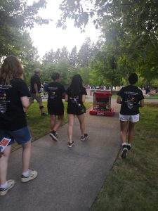 Four girls on the Wilsonville robotics team showcase their robot at a 2024 Wilsonville community event. With a female-heavy roster, Error Code Xero is a team that empowers young women seeking education in STEM. Photo taken by Olivia Sheng.