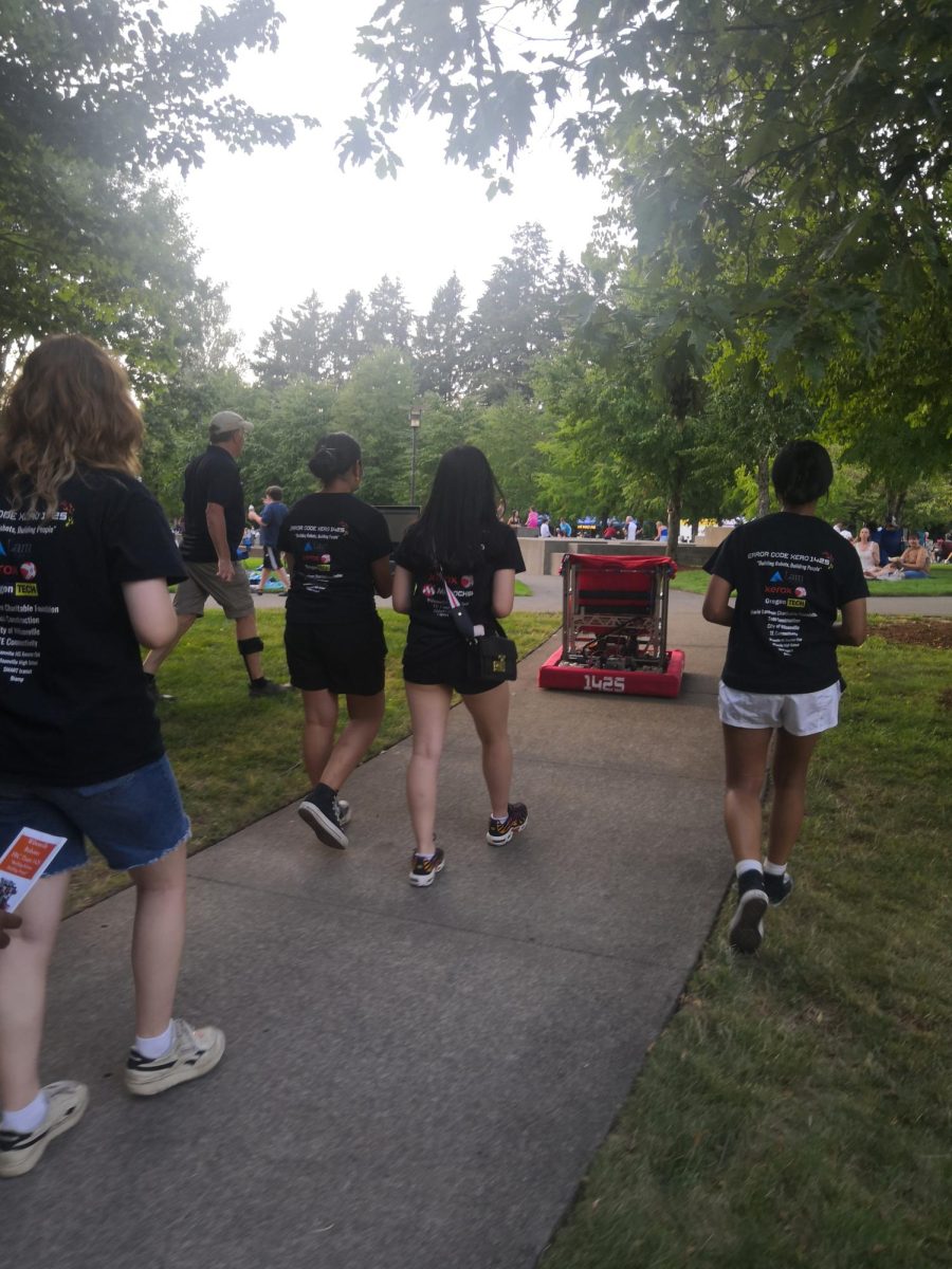 Four girls on the Wilsonville robotics team showcase their robot at a 2024 Wilsonville community event. With a female-heavy roster, Error Code Xero is a team that empowers young women seeking education in STEM. Photo taken by Olivia Sheng.