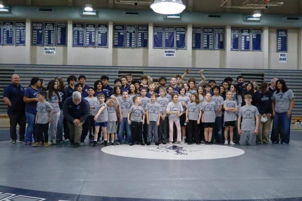 Youth wrestling takes photo with high school team to see their future.