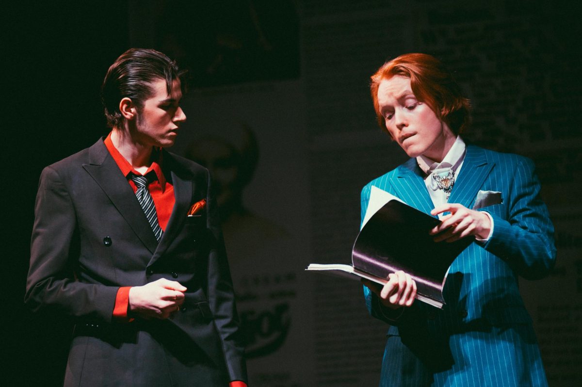 Arthur Roeder (Skyler Hopper) and Charlie Lee (Axel Lauthner) receive a report from Dr. Cecil Drinker (Stevie Binns). The report explains safety concerns found within the U.S. Radium Corporation. 