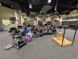 AP Music Theory students are pictured in the band room, where the class takes place. The small class size and rigorous curriculum provide high school students with the resources necessary to develop musical literacy and proficiency. Photo taken by author.