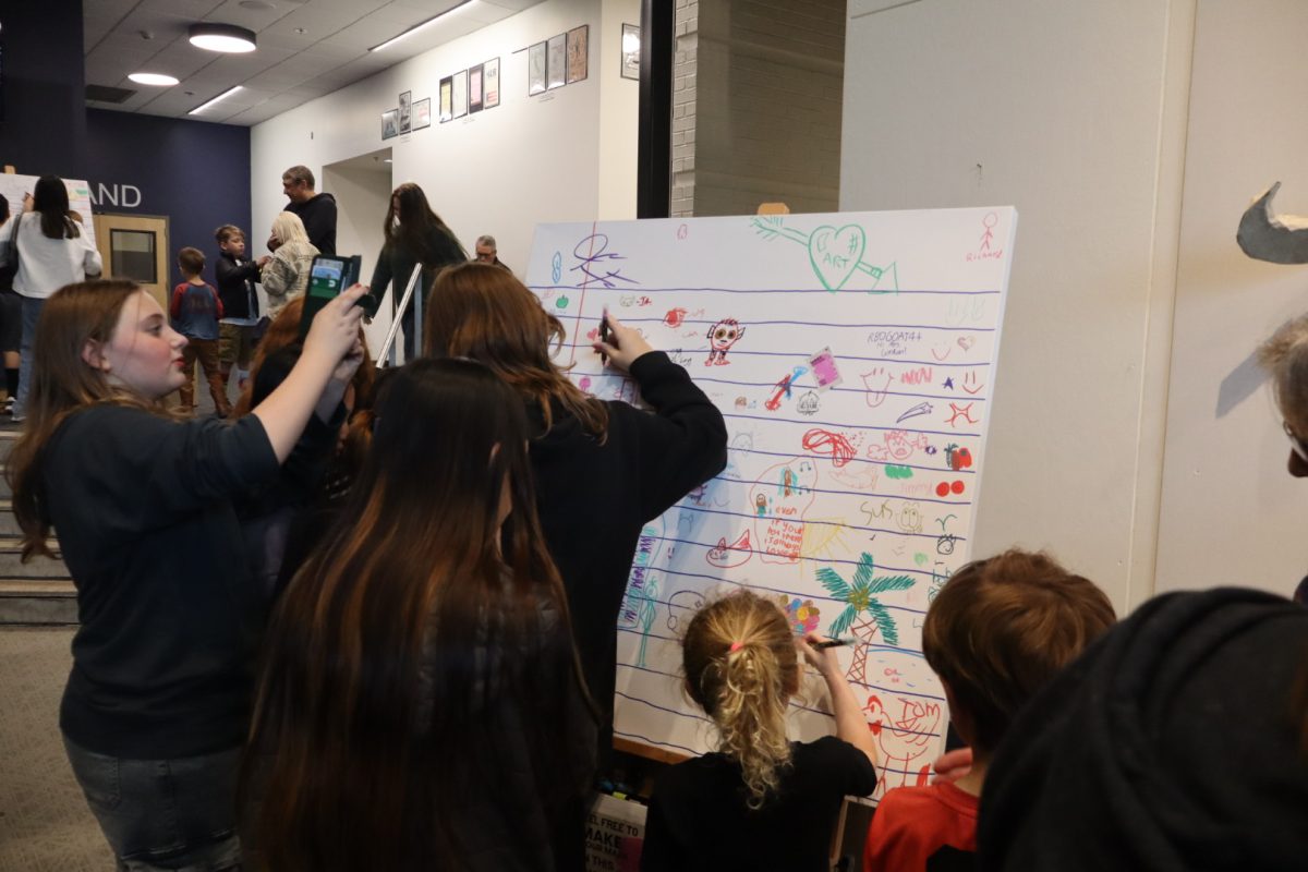 Canvas placed around the PAC lobby stood next to papers describing to "Make Your Mark." Pushing people to doodle and draw on the canvas' to create a community art piece. 