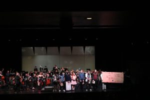 The band and orchestra seniors stand at the front of the stage to receive recognition at their final concert. A bittersweet night, director Chad Davies shared that while sad to see them leave, is excited for their future pursuits, knowing that their investment and dedication to music will serve them well beyond high school. Photo taken by Kevin Bruce.