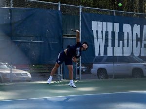 Senior Ted Lee serving the tennis ball in a strong caliber match showing the fun and competive aspects of the game of tennis not only at Wilsonville but around the nation.
