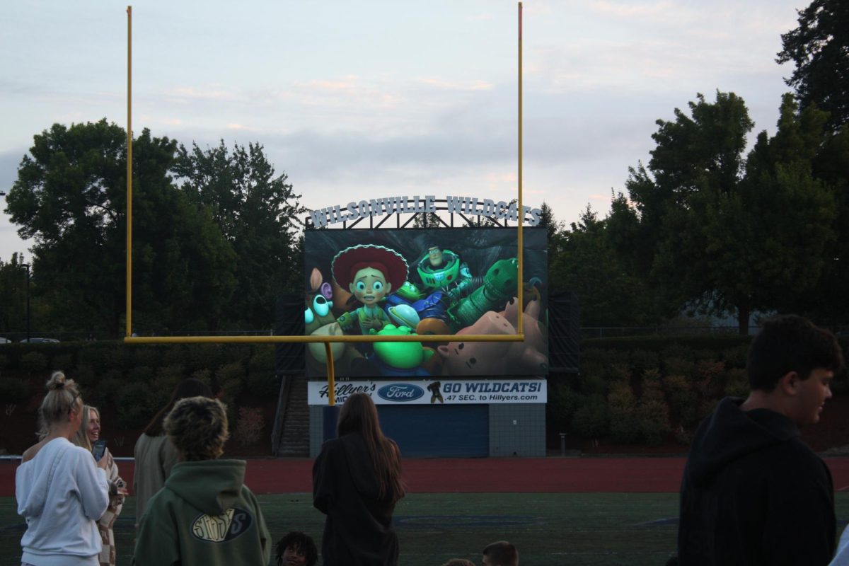 Students gathered on Wilsonville's main field within Randall Stadium. Showing is the movie Toy Story 2.