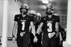 Senior football captains RIddick Molatore (left) and Luke Carli (right) emerge from the "Wildcat" tunnel before the kickoff against Sandy. Before each game, Wilsonville football holds pep talks in the locker room and march together onto the field.