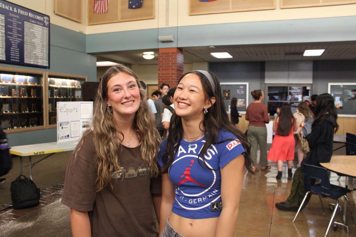 Paige Hibbard and Abby Khamvongsa smile for a picture as they walk along the clubs in the cafeteria. Paige adds, " I joined Spanish honor society because I've been a part of the dual language program for a while. I am really excited to start participating in the activities."
