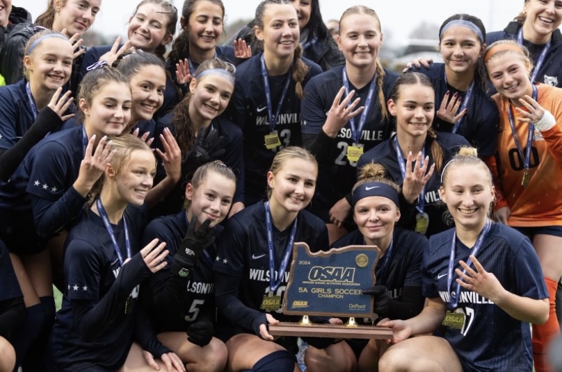 Wilsonville girls' soccer poses for a picture with their 4th state championship title. While their legacy is strong, this year's team works to play up to the reputation left by a bloodline of previous Wildcats. 