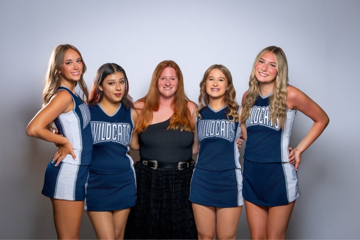 Head Coach Sydney Mcgraw takes a picture with her 4 seniors on the Wilsonville High School cheer team.  She has had a great impact on the team and gave a new name to the Wilsonville HIgh School cheer team.
