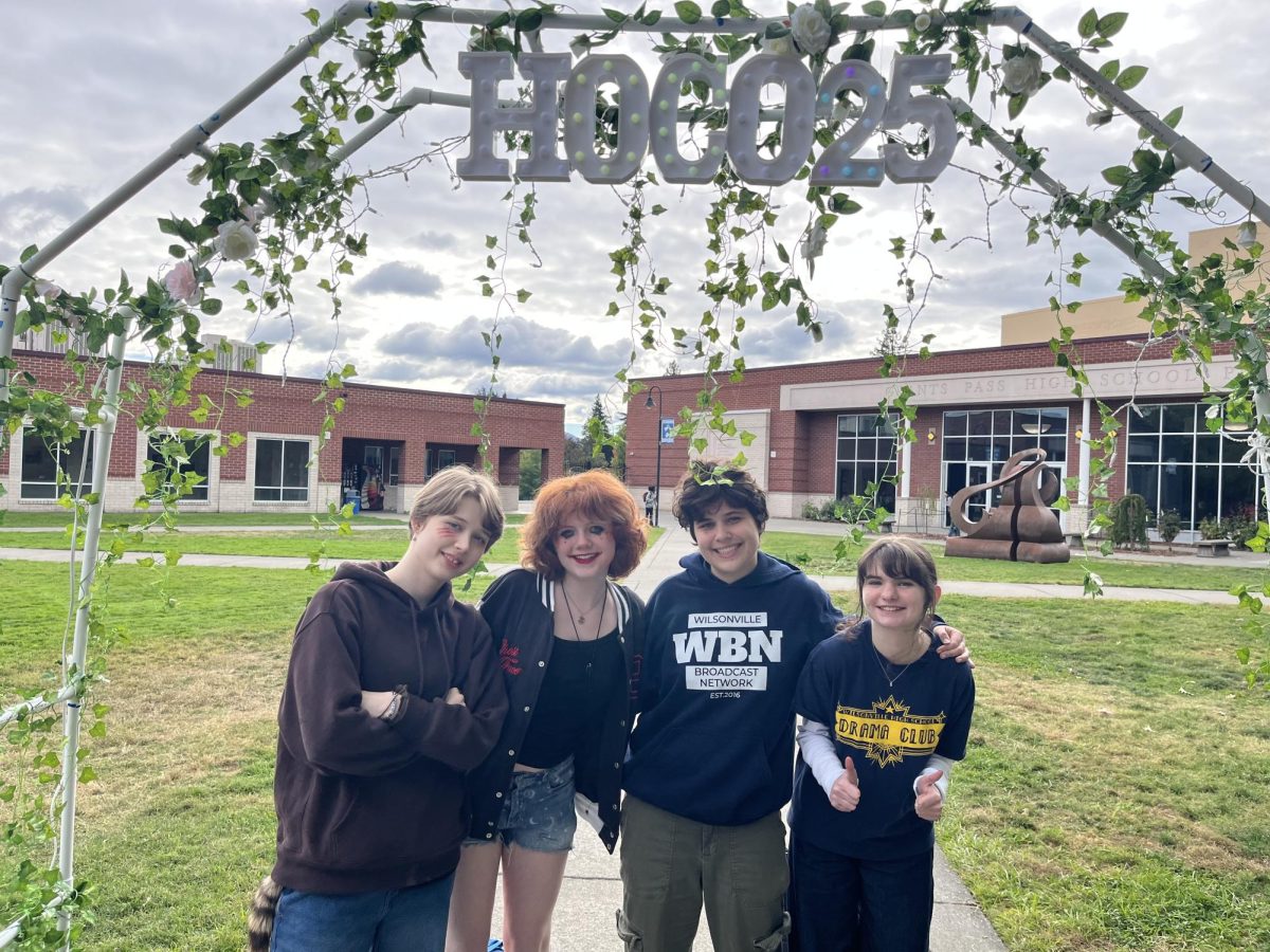 Left to right: Stevie Binns, Taylor Nichols, Ethan Spisak, and Aislinn Quinn finish the day off at Instafest. Posing underneath Grant Pass's HOCO decorations for their dance later that night. 