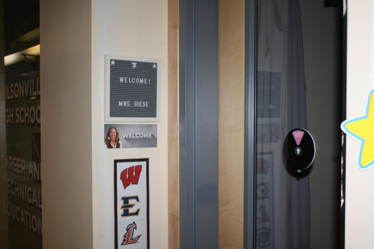 A picture of Mrs. Giese with a welcome stand resides in front of her college and career room. Her room is located right across from the office.