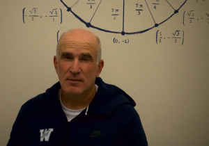 Mr. Barkley is featured in front of the iconic unit circle in his classroom, a tool students musnt't take for granted! He would later review this picture, calling it "prefect," because, "it looks like a mug shot."