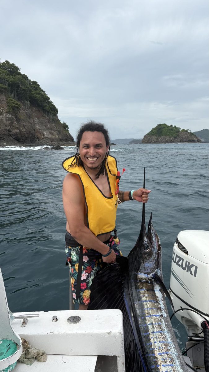 A photo of Canales holding a swordfish in Costa Rica on an EF tour with his students. This trip allowed for further connection with some of his spanish students, and also an opportunity for them to use this skills learned in his classes.