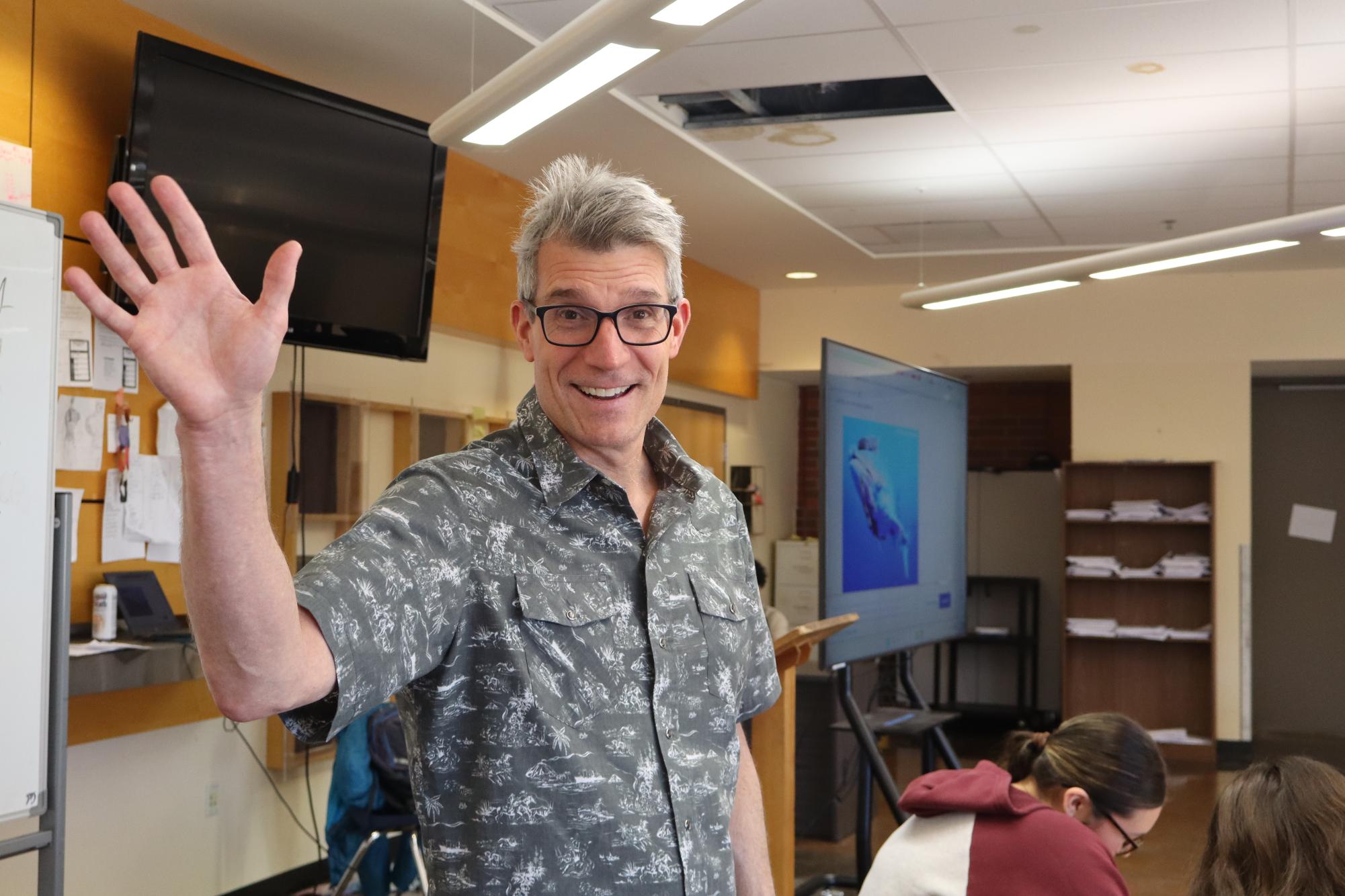 Mr. Hummelt stops teaching for a minute to wave to the camera. His goal is to share his knowledge with all his students when they come into his room daily.