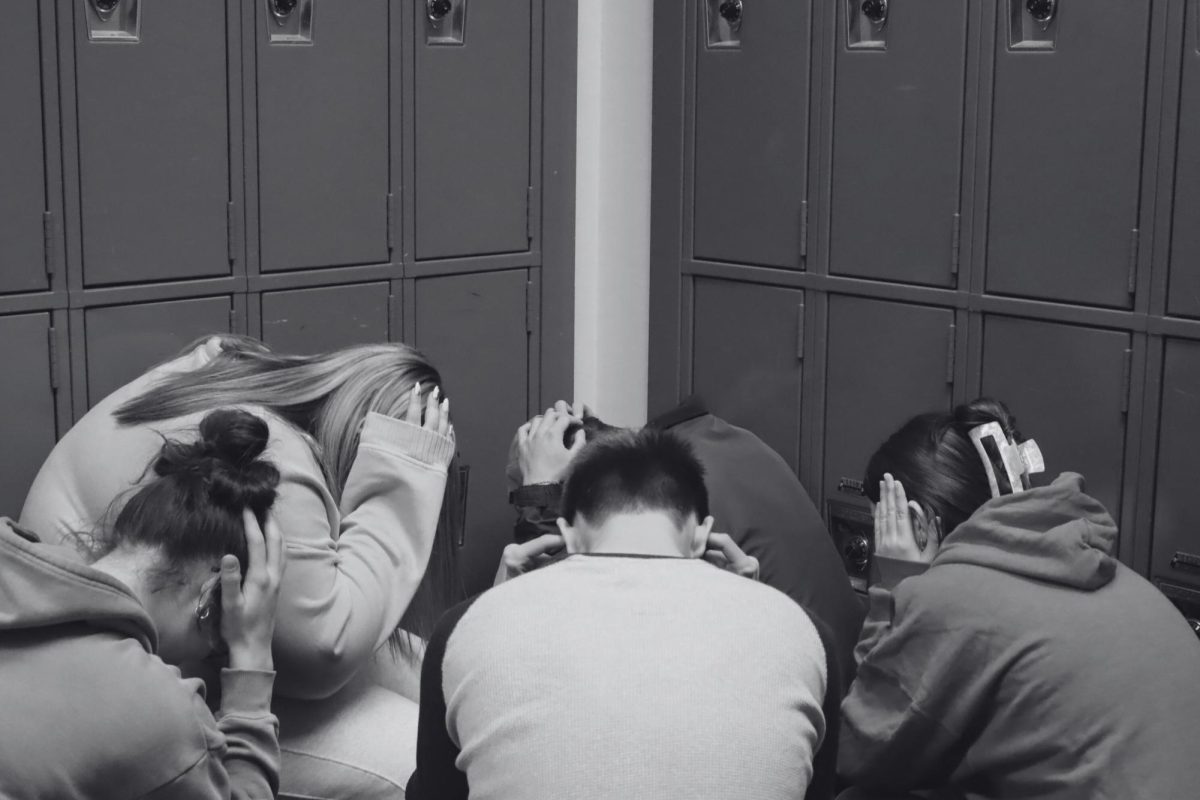 Students huddle in fear in a corner at school. This mimics what students are supposed to do during an actual lockdown or active threat. Safety drills are practiced at Wilsonville High School regularly in preparation for unsafe events. 