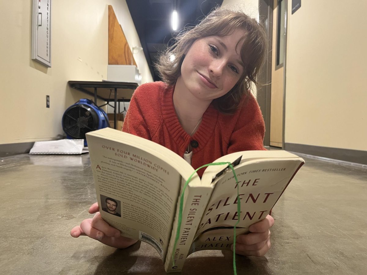 Mia Evans lies sweetly while reading her book "The Silent Patient." Taking a moment to read allows her to relax and continue to build her media literacy ability. 