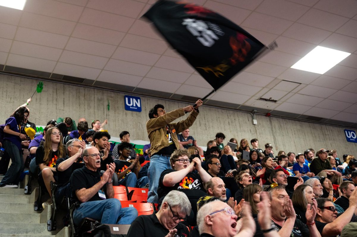 Error Code Xero rallies together to root on their bot in the upcoming match.  
 As their number is called over the PA, they cheer in unison to show their team spirit.   Photo by Sam Faveluke Used with permission). 
