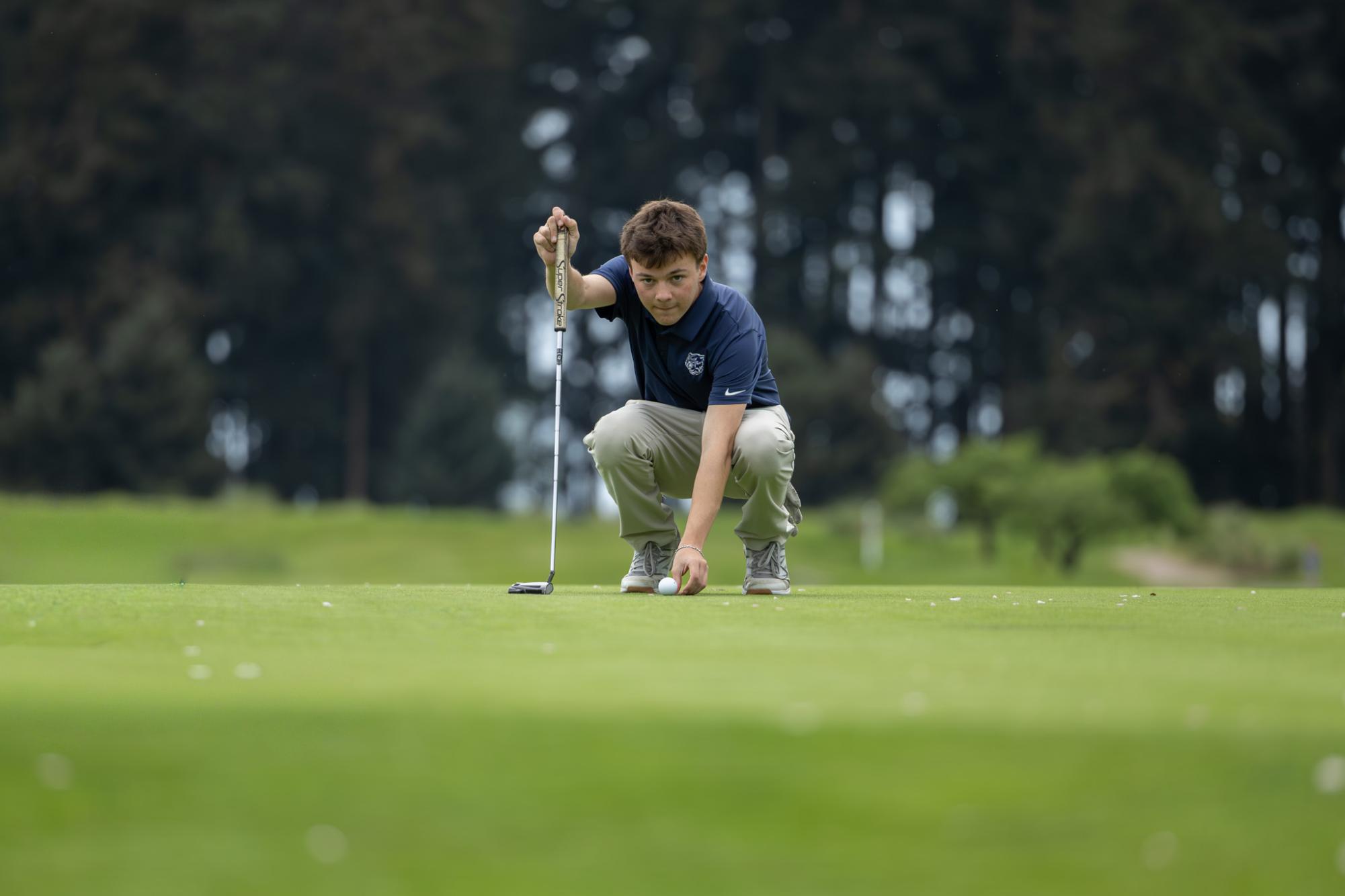 Senior Simon Bonfiglio measures a shot at a boys golf match held at Langdon Farms on April 20th. Wilsonville hosted the event and took 3rd place.