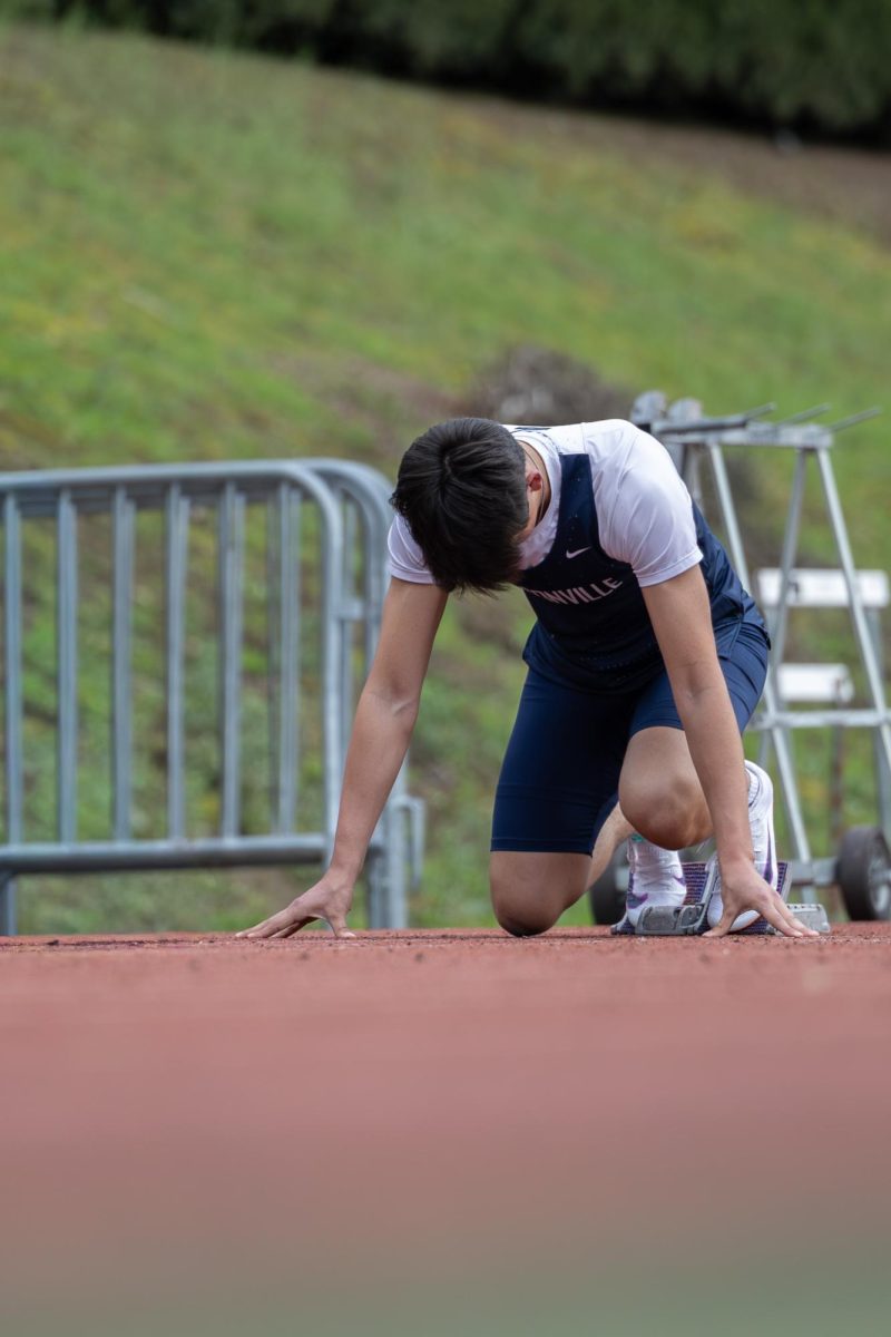 Junior Ryder Rodriguez prepares to run a 100 meter in a track meet against West Linn. Track can be very helpful for athletes in different sport wanting to improve on there speed and strength and conditioning.