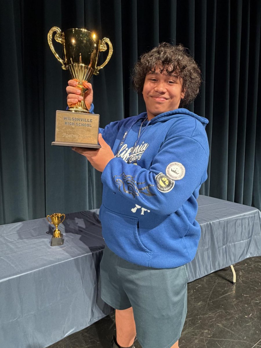 Noah Yandall proudly shows off this gorgeous trophy at the end of the poetry slam.  The trophy will live in Ms. Asher's room for the second year in a row.  Photo by Shannon Heaton, used with permission.