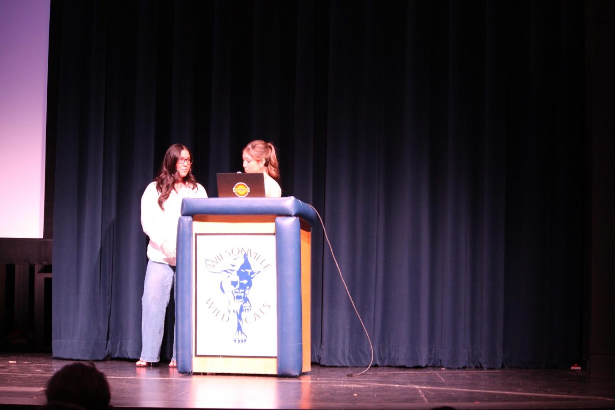 Freshmen Leah Campbell and Sophia Parra present their Life Class proposal to the entire 2029 graduating class. They plan on refurbishing and renewing a mural that students see when walking down to the weight room. 